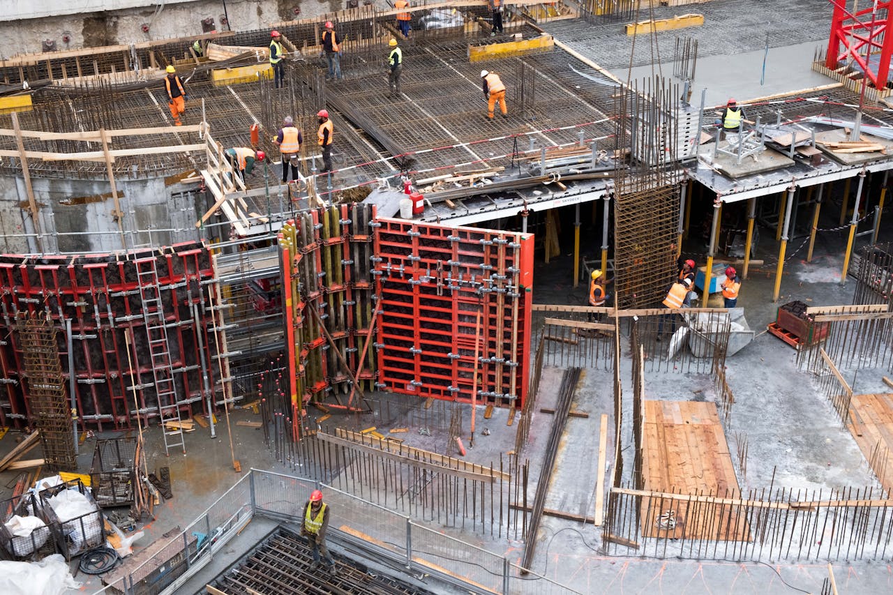 about-02 Industrial construction site with workers in high visibility clothing at a steel framework structure.