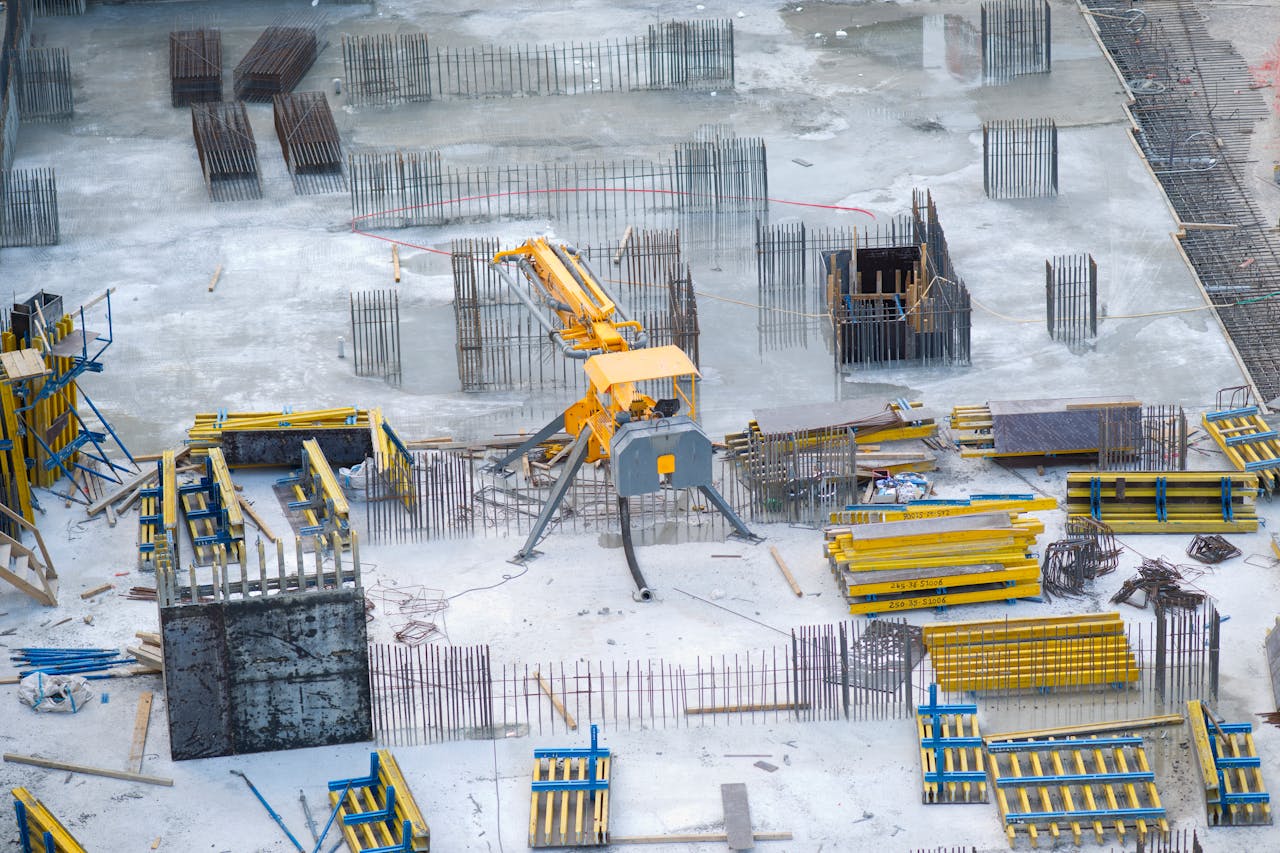 about-01 Aerial view of an active construction site with heavy machinery and building materials.